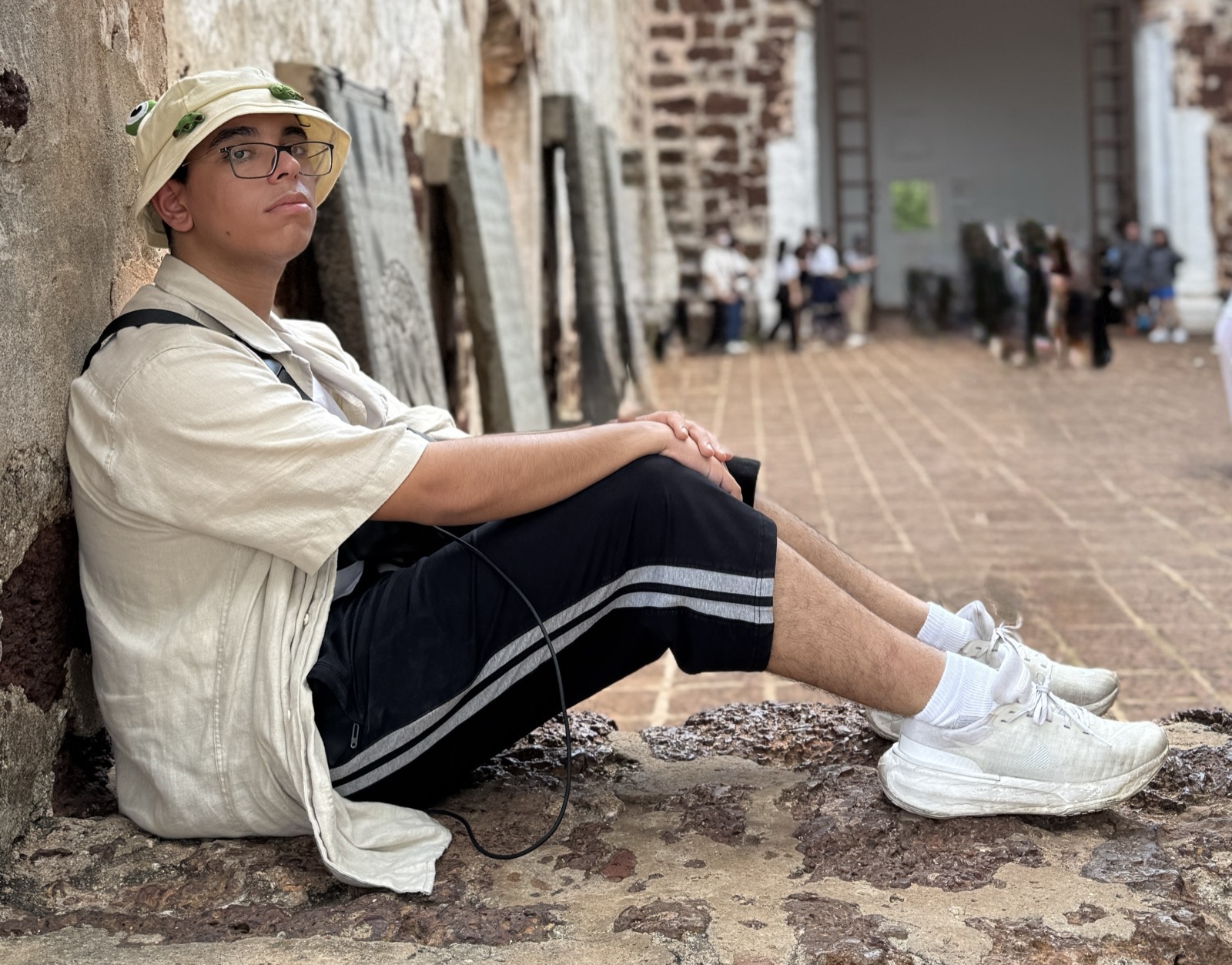 Yousof Selim sitting in a stone doorway in Melaka, Malaysia